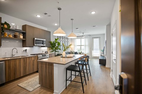 an open kitchen and dining area with a white counter top